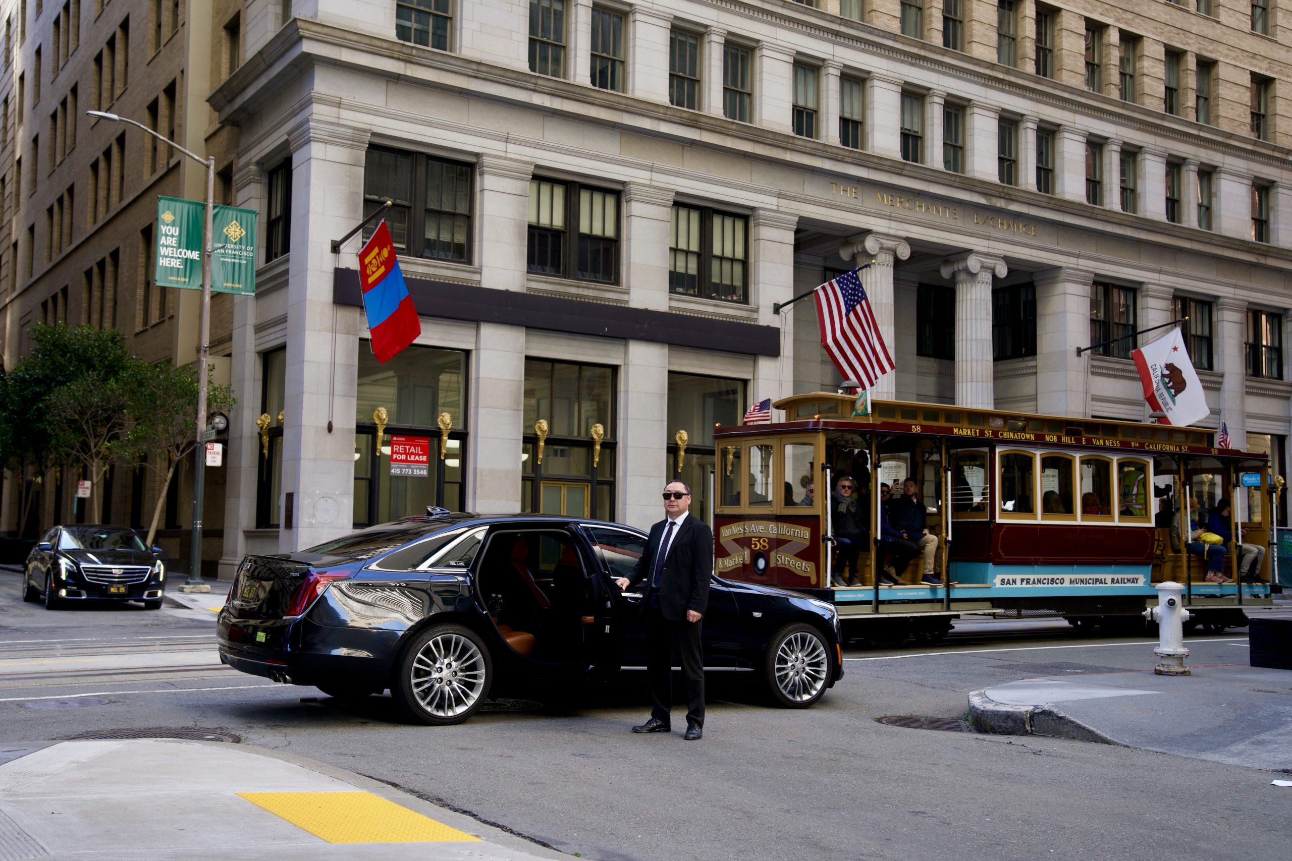 A chauffeur opening a door in front of the Mongolian embassy in San Francisco