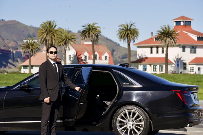 A MGL Limo chauffeur opening the door to a limo sedan