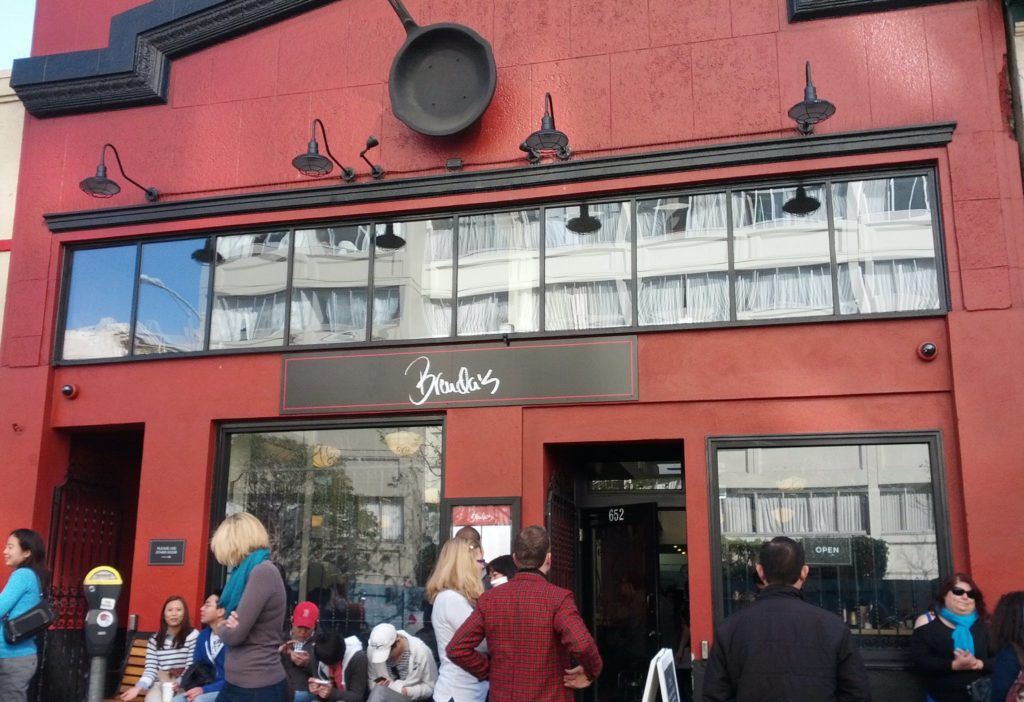 Brenda French Soul Food Front, a red building with people waiting in line