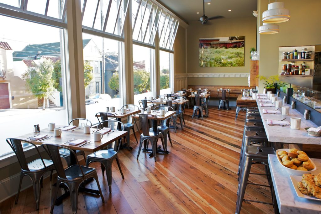 Plow SF restaurant interior with black metal chairs and wood floors